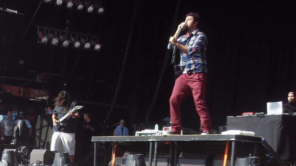 Deftones biography portrait — band members performing on stage at a festival.