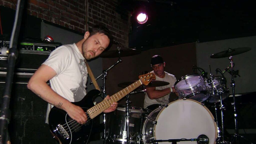 Dredg biography portrait — Drew Roulette and Dino Campanella performing live on stage.