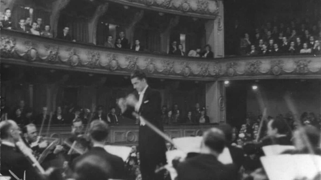 Herbert von Karajan biography portrait — conducting an orchestra.