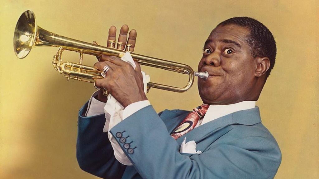 Louis Armstrong biography portrait — legendary jazz musician playing his trumpet in 1947.