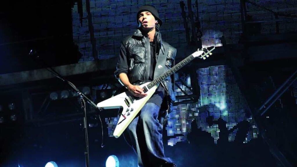 Tom Kaulitz biography portrait — performing guitar on stage during a Tokyo Hotel concert.