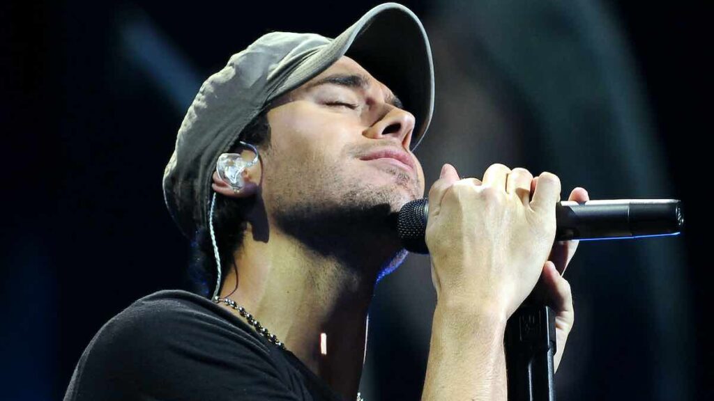 Enrique Iglesias biography portrait — performing live on stage at a Walmart store concert in 2010.