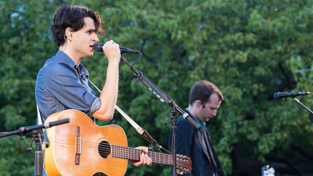 Vampire Weekend biography portrait — performing live on stage at a music festival.