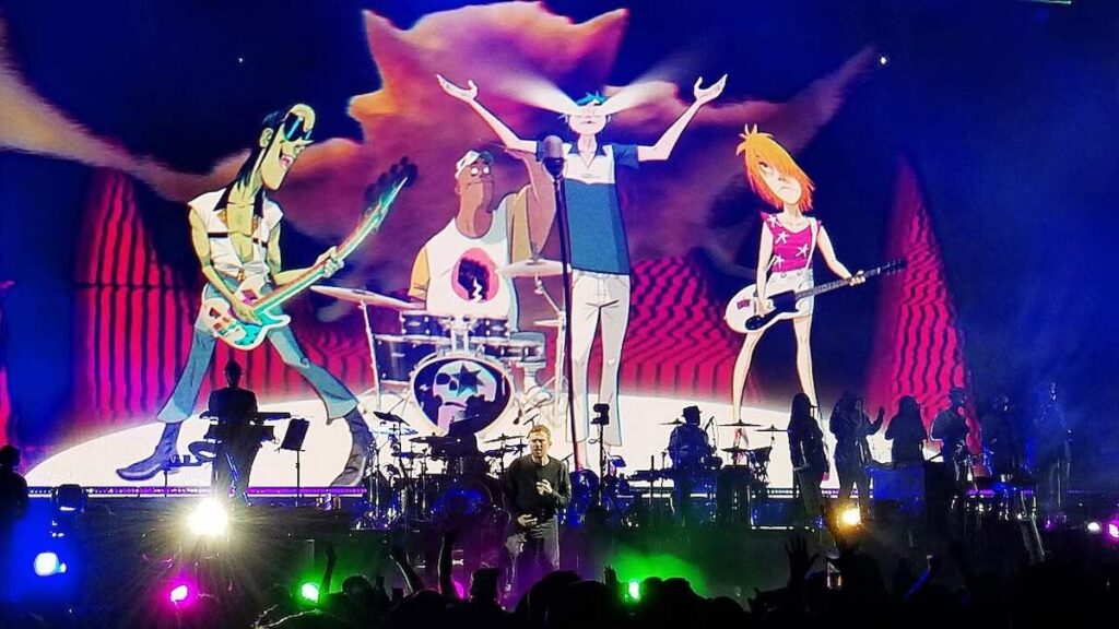 Gorillaz biography portrait — performing live on stage at Barclays Center in Brooklyn during 2018 tour.
