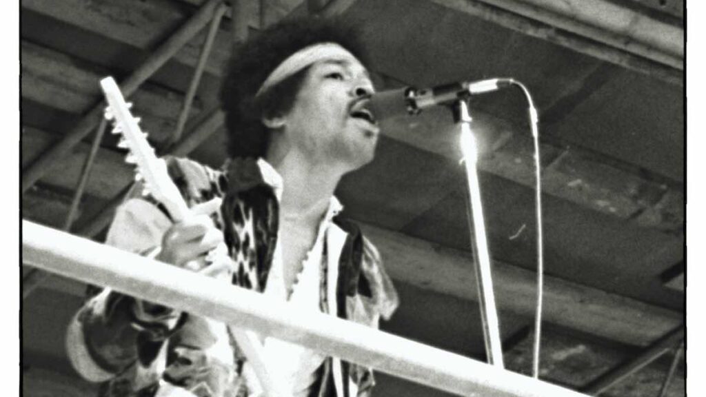 Jimi Hendrix biography portrait — performing live on stage at a music festival in 1970.