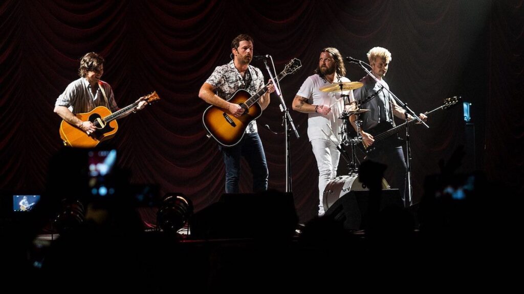 Kings of Leon biography portrait — performing live on stage at Sheffield Arena in 2017.