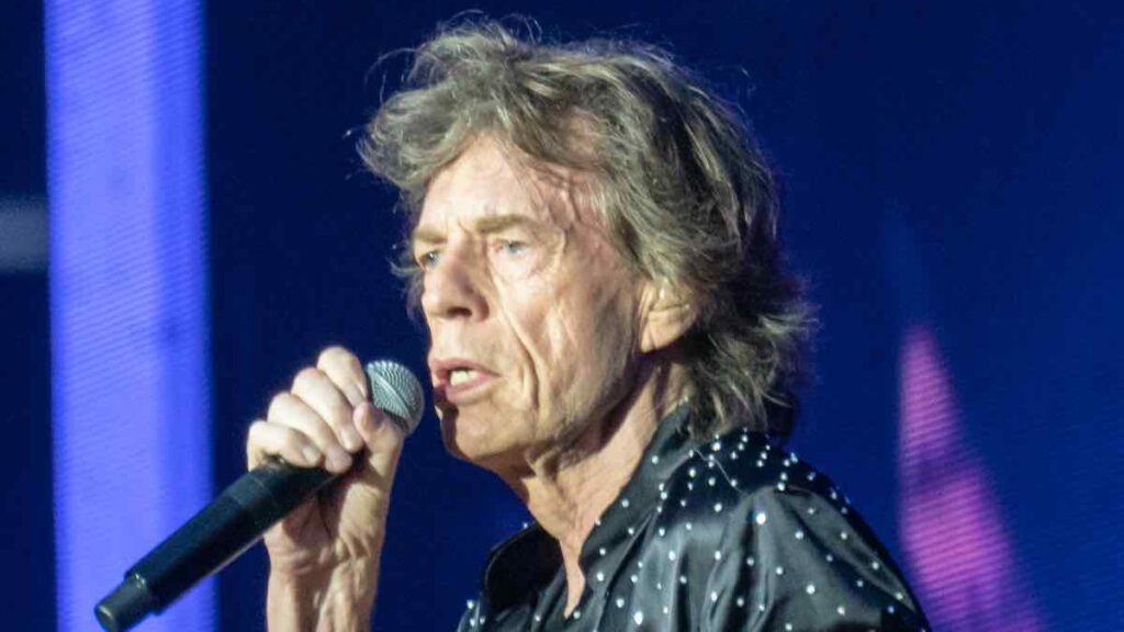 Mick Jagger biography portrait — singing during a London Rolling Stones concert in 2018.