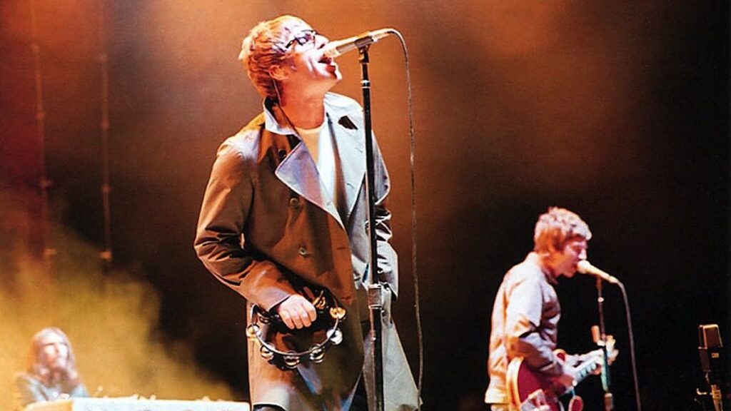 Oasis biography portrait — Noel and Liam Gallagher performing on stage in 2005.